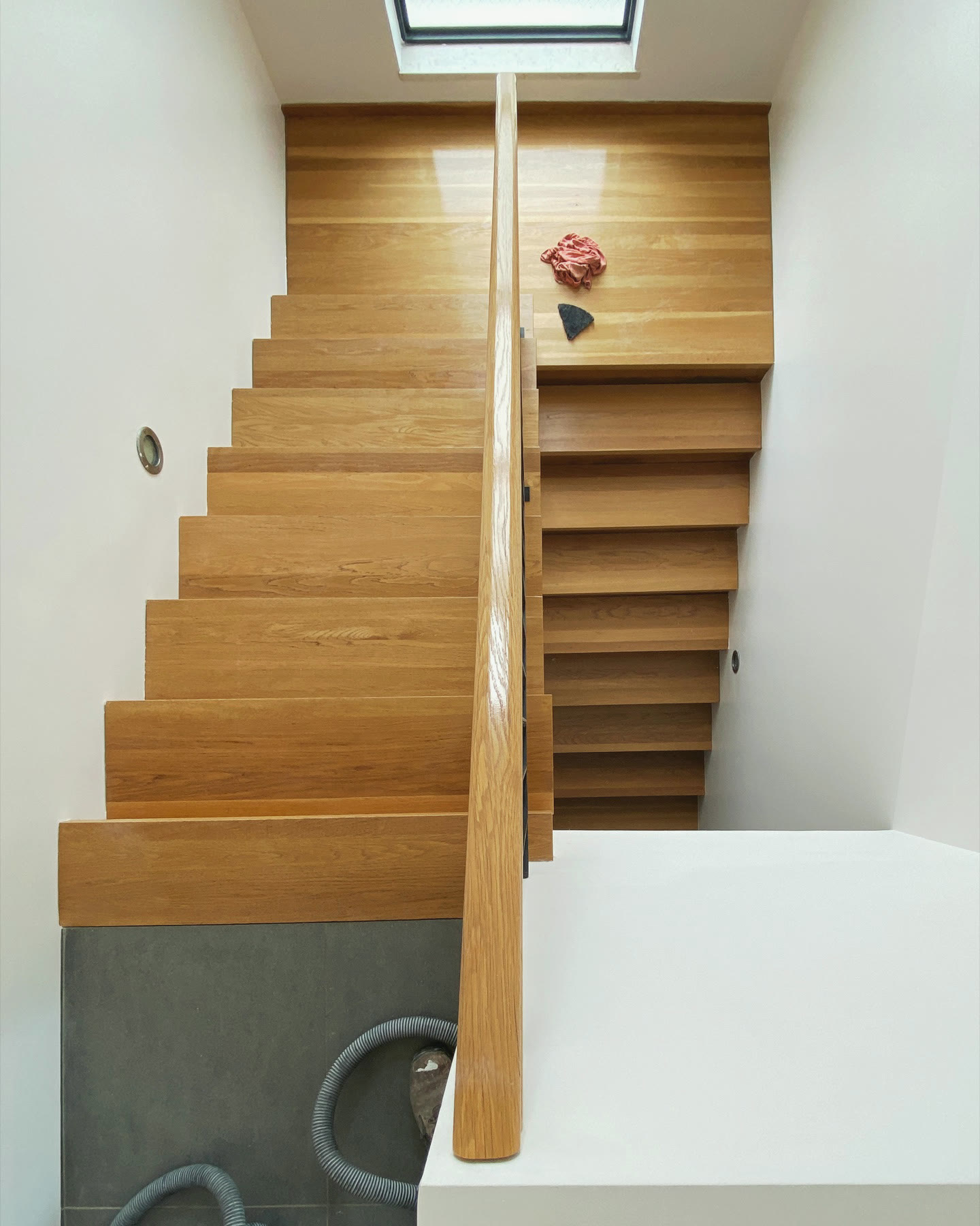 A stairwell with freshly painted walls, lit from above by a skylight